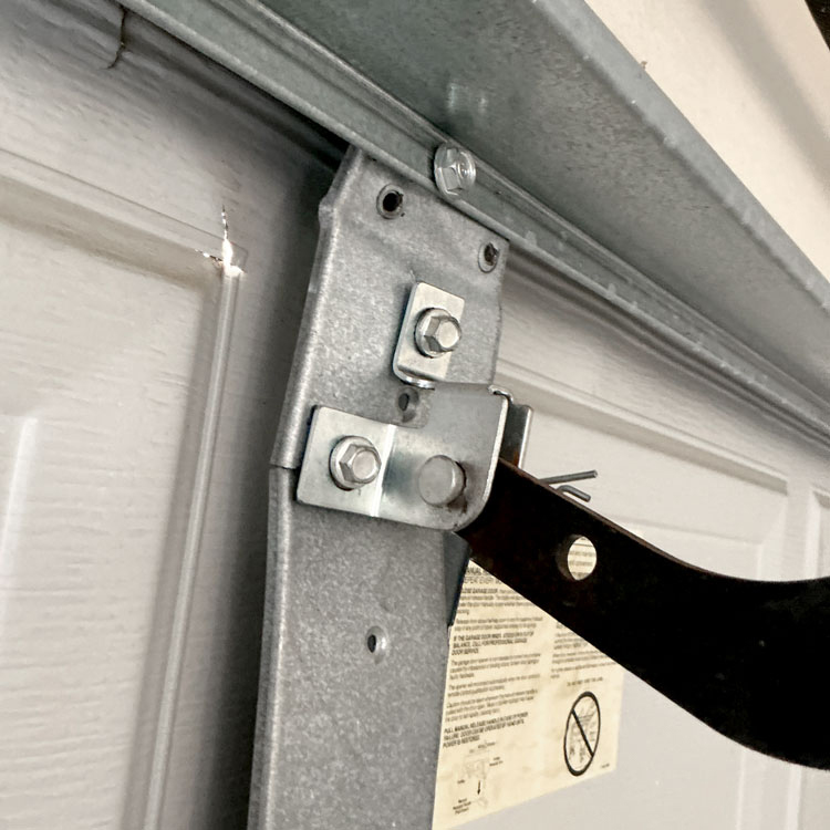 Garage door repair in Dallas, TX with an operator reinforcement bracket reinforcing a cracked garage door center stile.