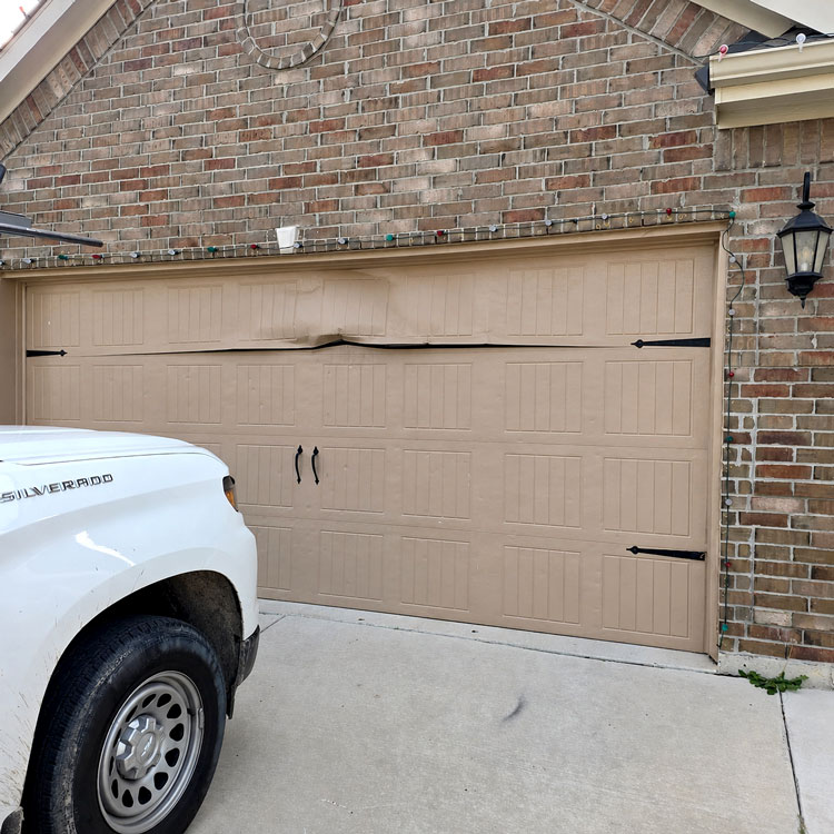 Warped and dented garage door before insulated door replacement in Fort Worth, Texas.