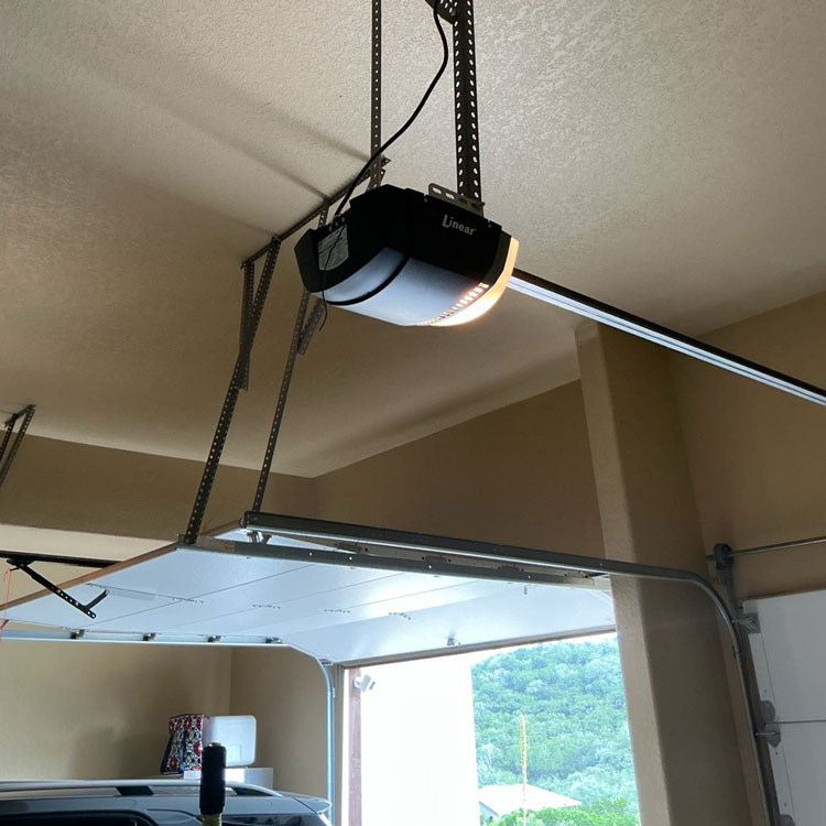 Garage door and opener receiving preventive tune-up and maintenance in San Antonio, TX
