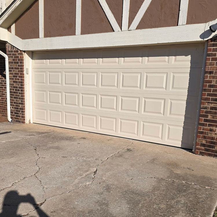 New white raised-panel garage door after replacing a door with cracked panels in Oklahoma City, OK